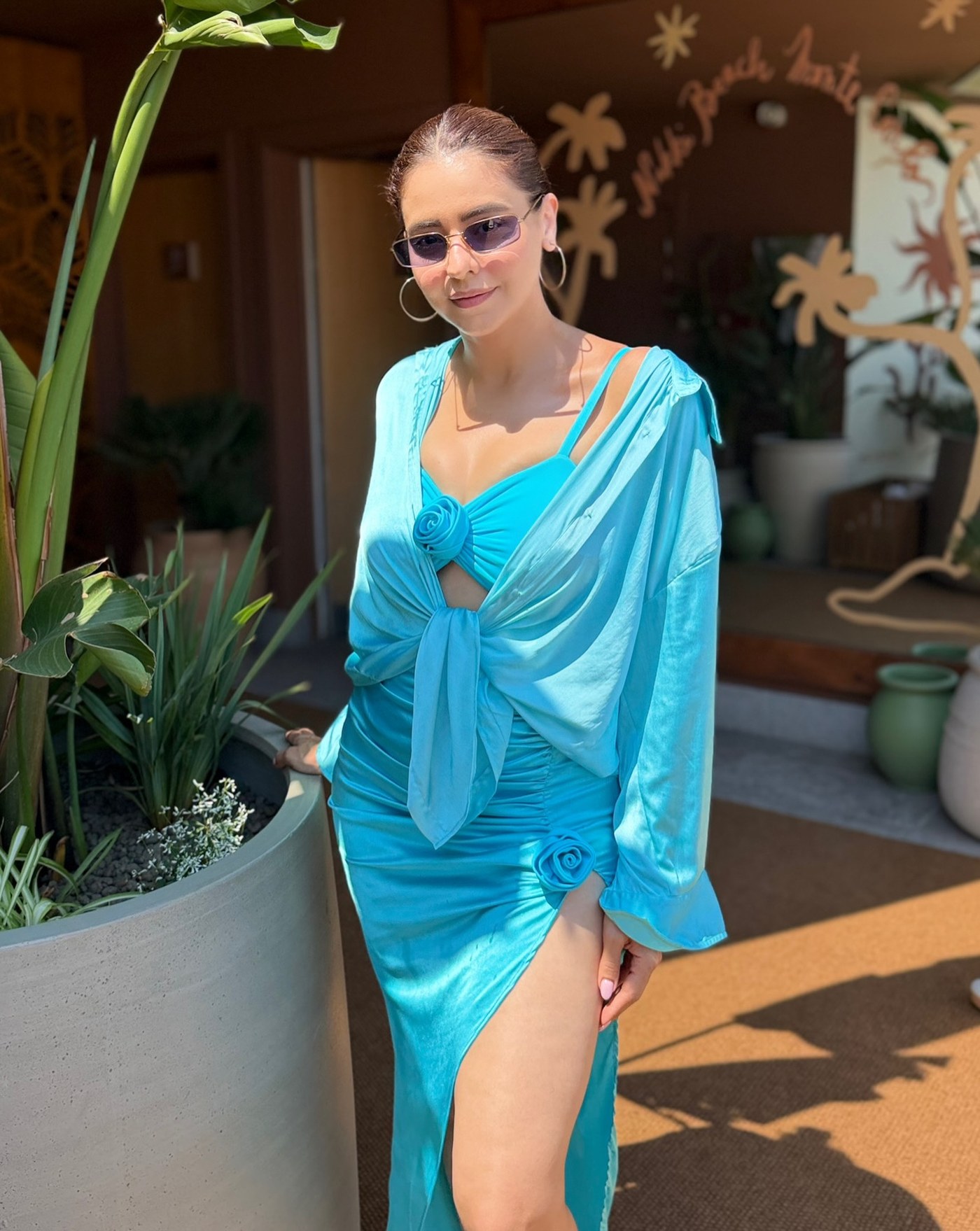 Aamna Sharif is captured in a close-up, mid-shot wearing an ensemble dominated by cyan and turquoise blue shades under bright natural light.