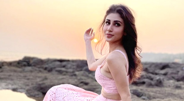 Mouni Roy poses in a stunning emerald green outfit with elegant styling and accessories.