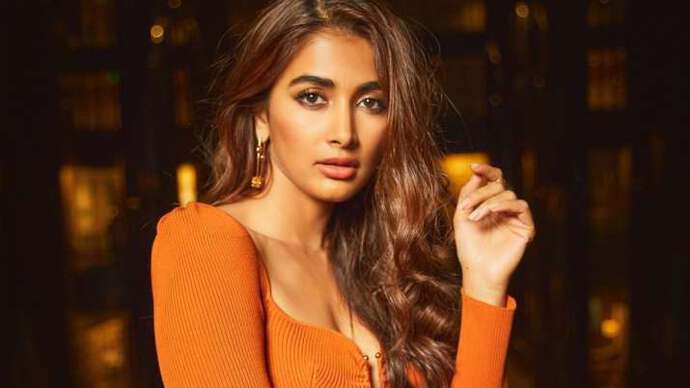 Pooja Hegde poses beautifully in a stunning outfit against a rustic backdrop.