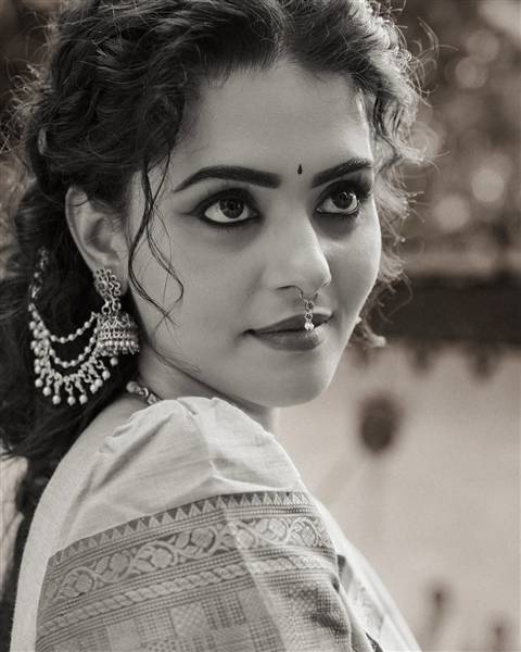 Swathishta Krishnan posing confidently at an event, showcasing a striking ensemble.