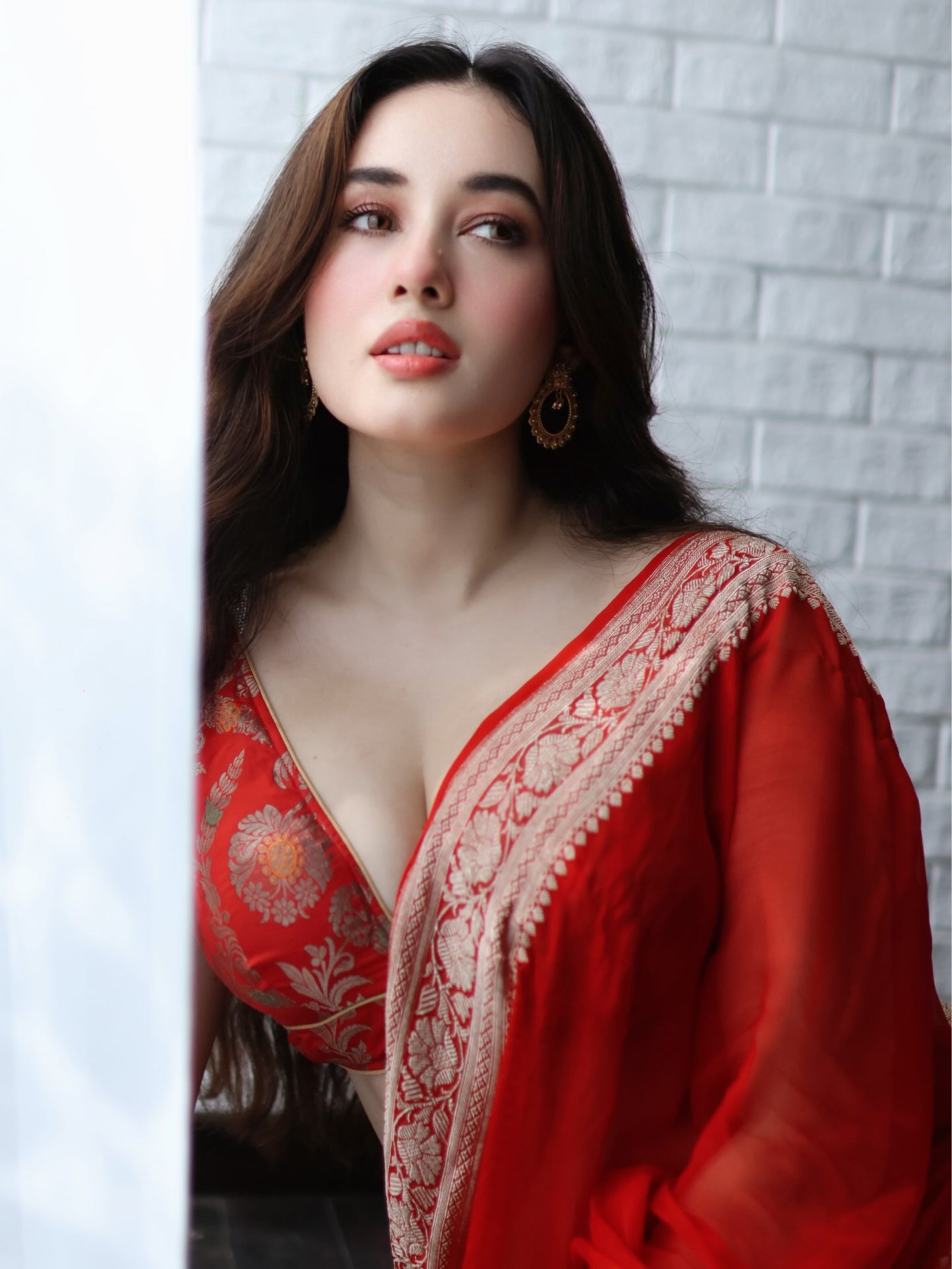 Aditi Budhathoki looks radiant and sophisticated draped in an ethereal red saree adorned with delicate gold work.