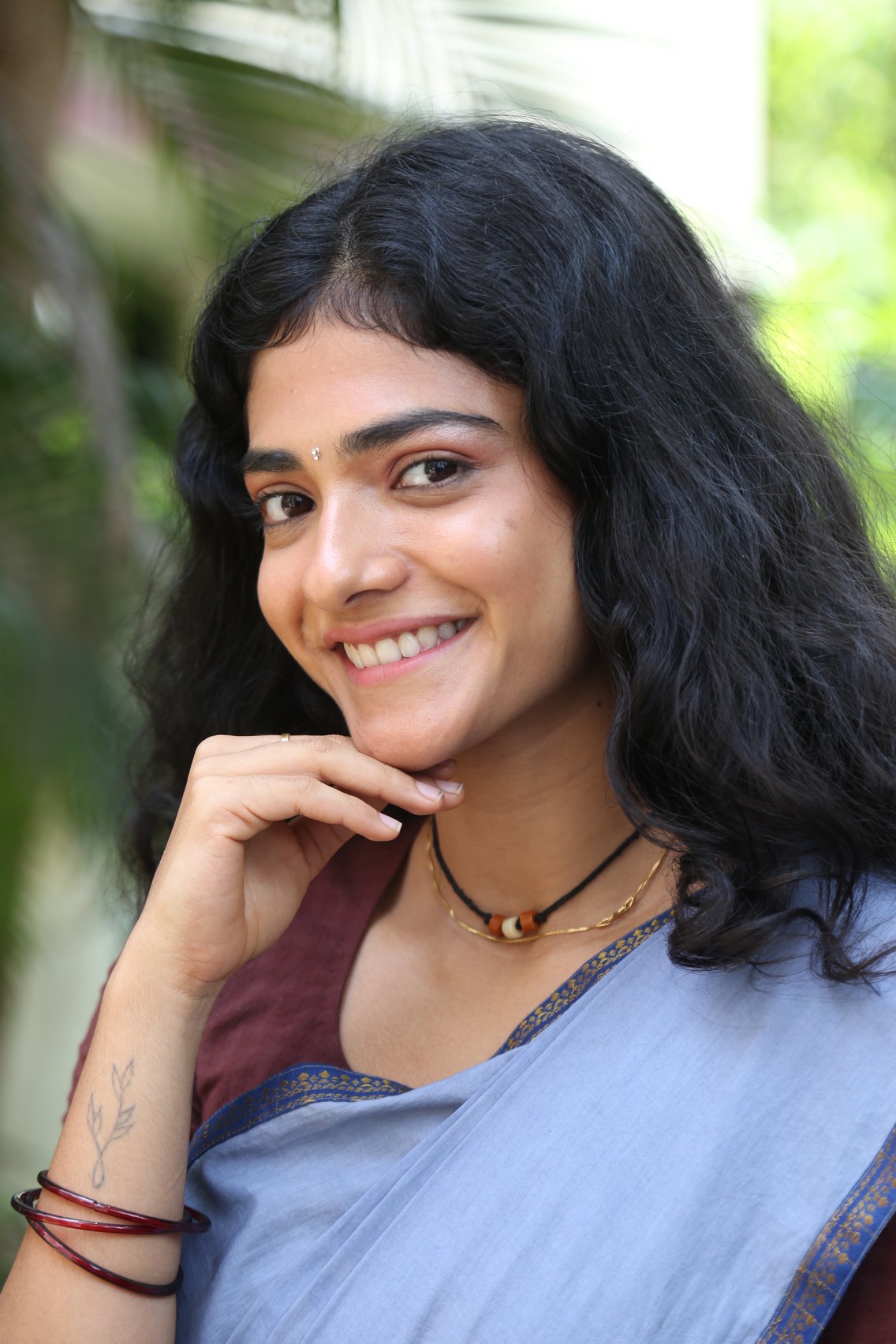 Ahilya Bamroo posing in a vibrant pink outfit with elaborate jewelry.