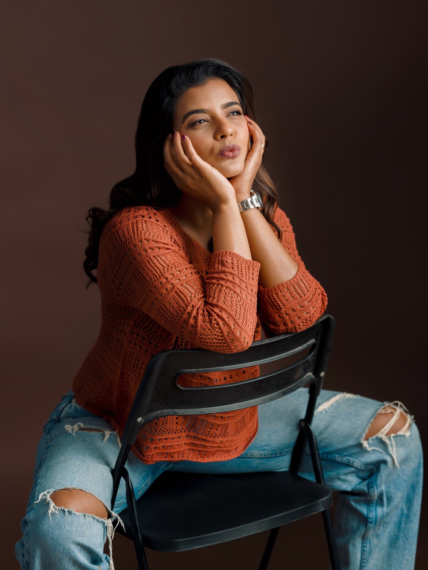 Aishwarya Rajesh rocking a warm, burnt-orange knit sweater with laid-back elegance.