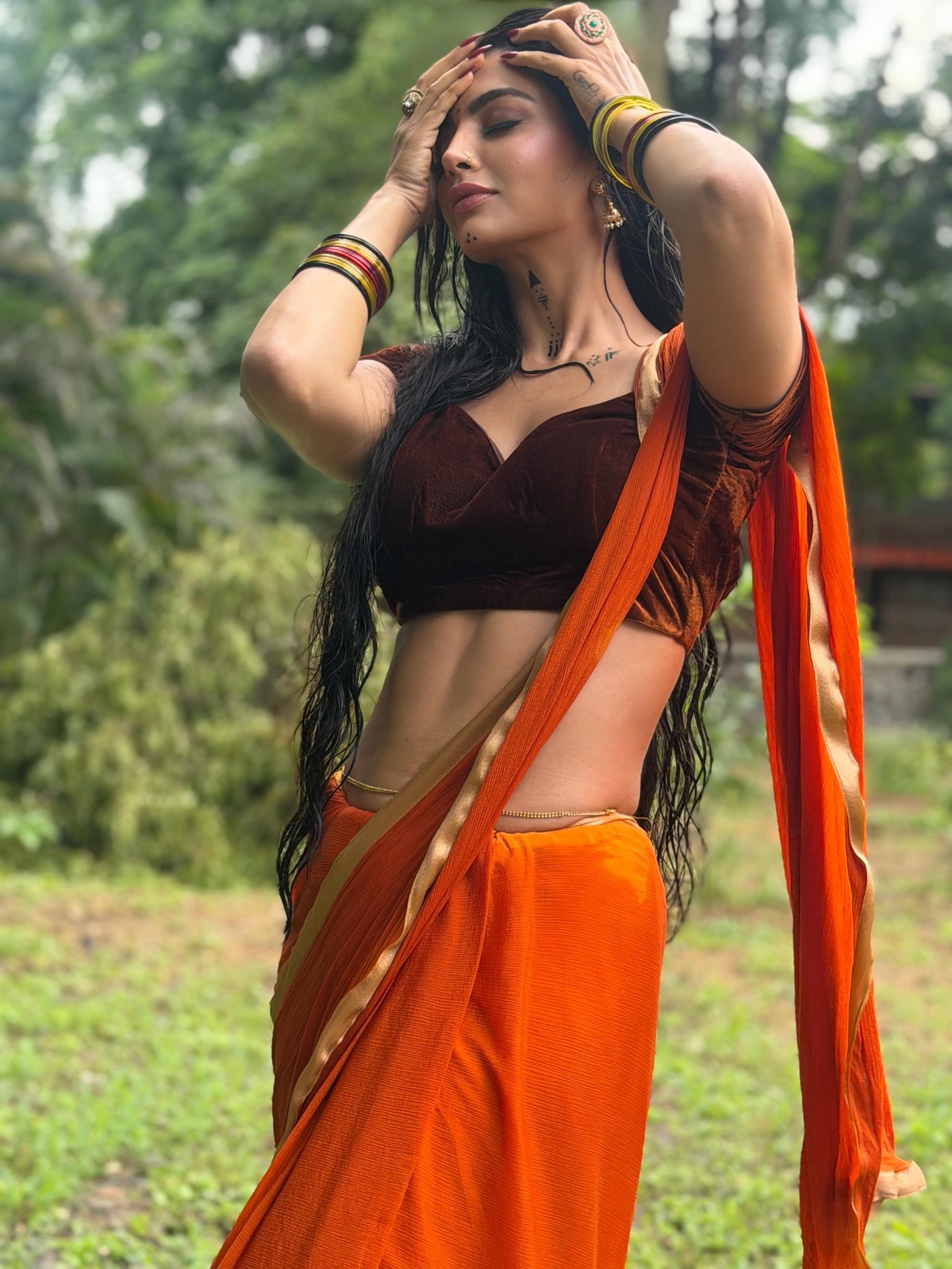 Akanksha Puri in a vivid orange saree paired with a sleek, fitted black blouse. - Photos & Updates