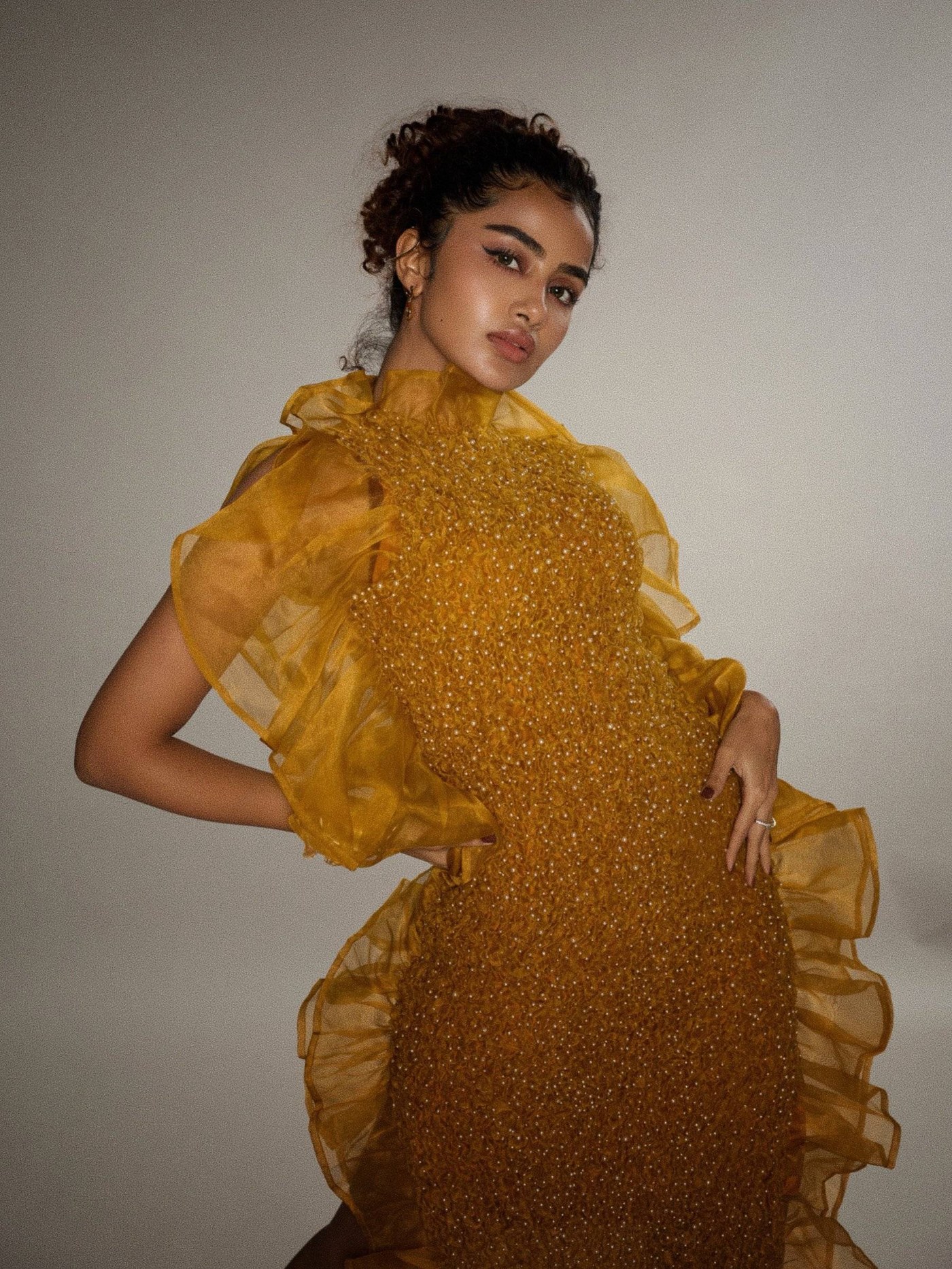 Anupama Parameswaran in a mustard-gold gown with sheer layers.