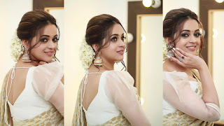 Bahavana Menon posing gracefully in a light-colored traditional outfit with soft smiles.