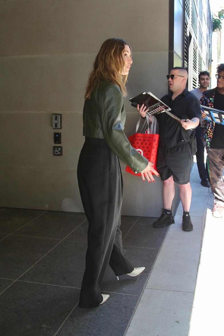 Betty Gilpin posing confidently at an event, showcasing a vibrant outfit.