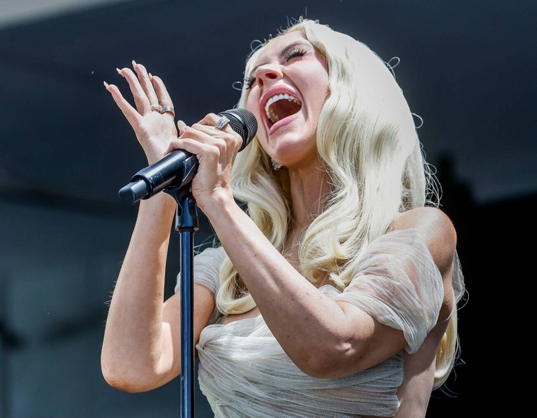 Christina Aguilera shines at a glamorous event, dressed in an elaborate and elegant ensemble.