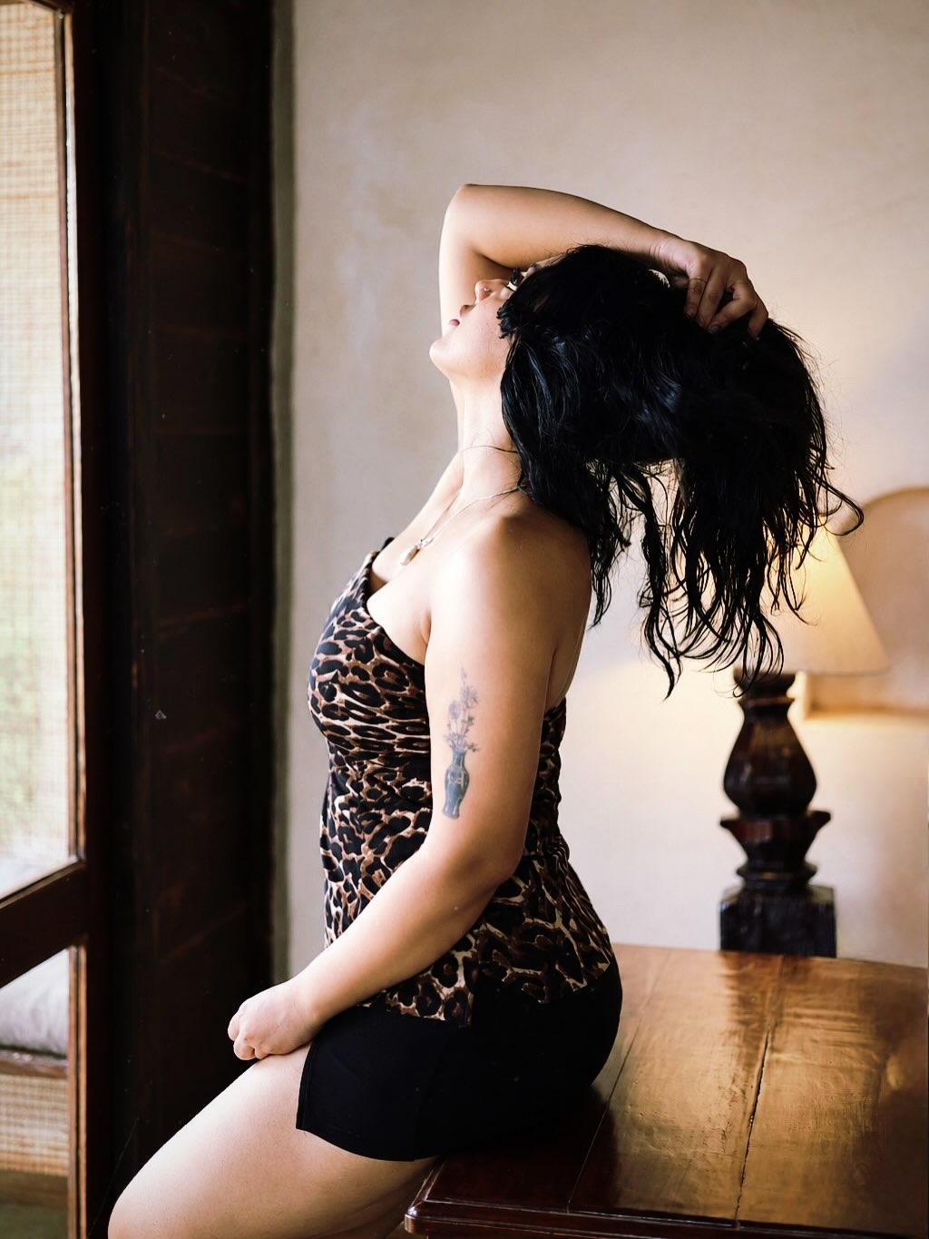 Deviyani Sharma seated in a leopard print top indoors.