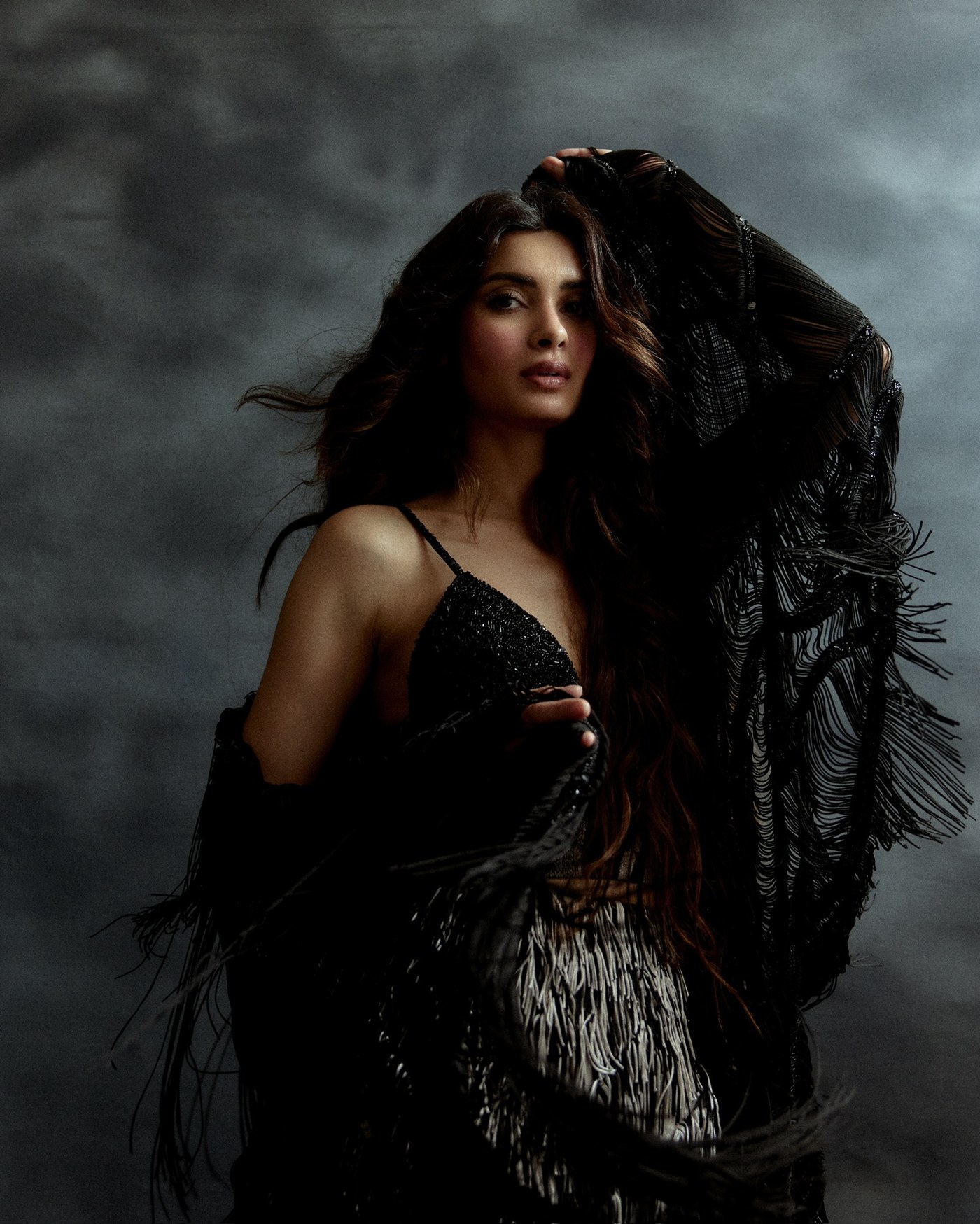 Diana Penty showcases a black and silver ensemble in a studio setting.