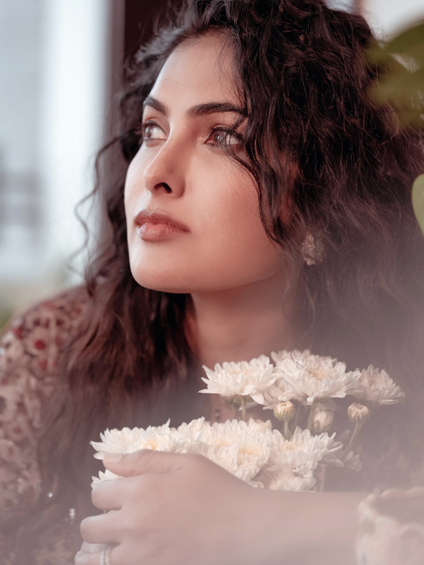 Divi Vadthya showcases an elegant embroidered ensemble featuring detailed floral work in soft earthy tones.
