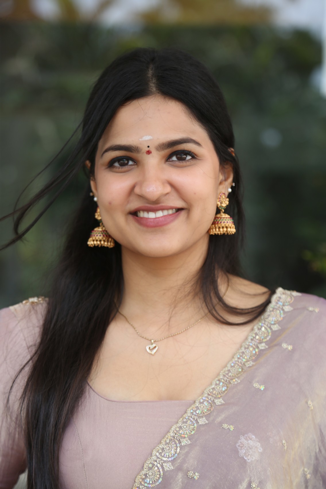 Divija Prabhakar showcases timeless elegance in a pastel pink ensemble against lush greenery.