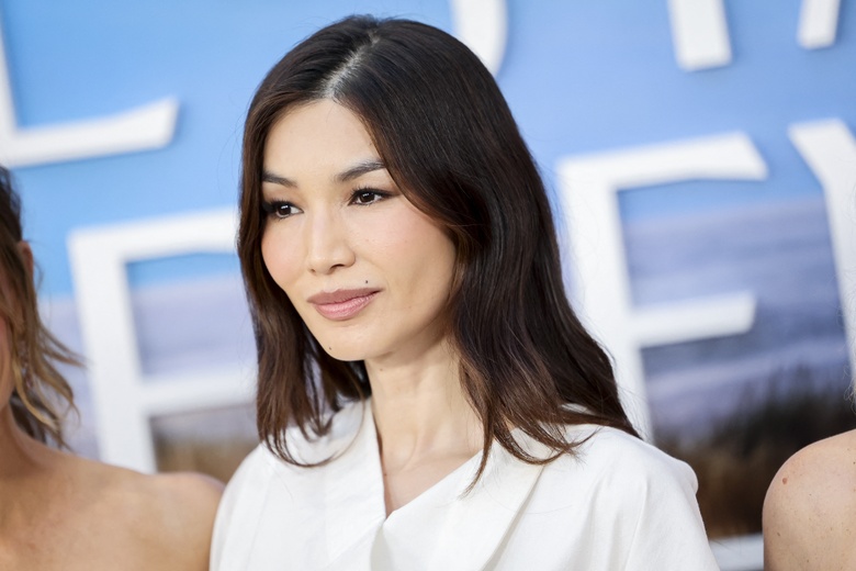 Gemma Chan poses elegantly on a red carpet at a major film festival event.