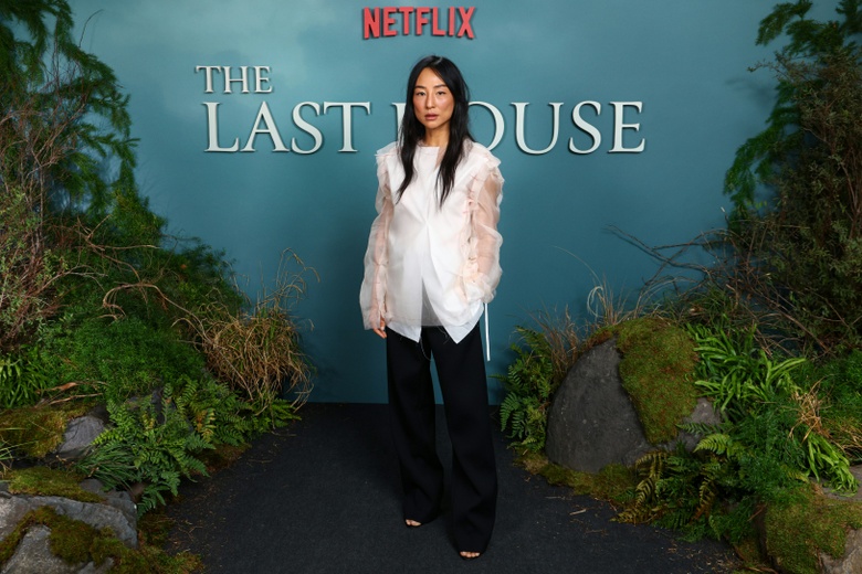 Greta Lee shines at a prestigious event, showcasing elegant evening wear on the red carpet.
