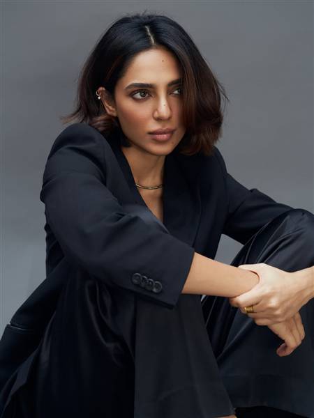 Sobhita Dhulipala poses elegantly on a red carpet beside a staircase.