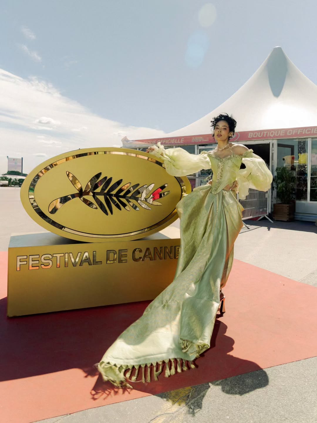Ishita Mangal posing outdoors in a light green, voluminous outfit against a bright blue sky.