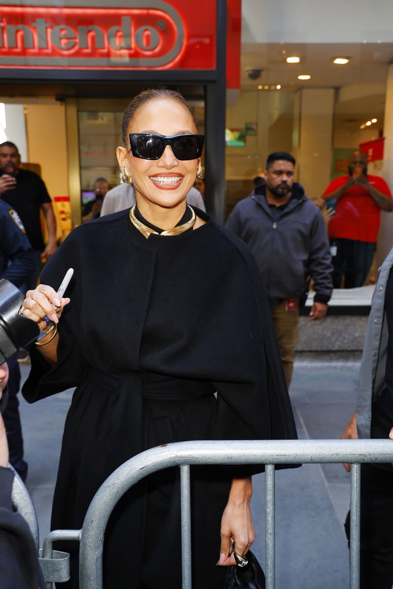 Jennifer Lopez posing confidently at an outdoor event, radiating vibrant energy.