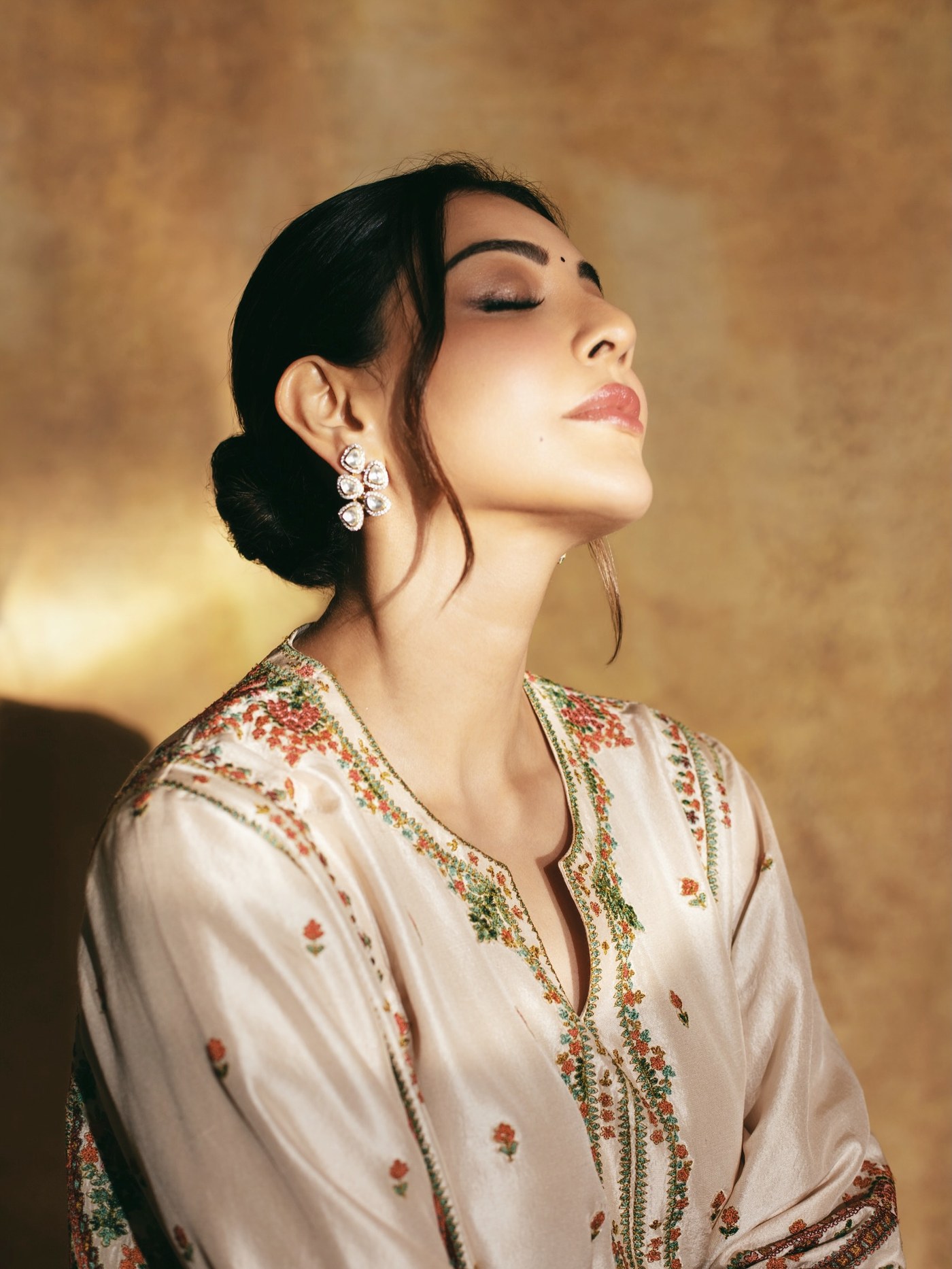 Kajal Aggarwal stunning in a cream-toned embroidered ensemble, showcasing timeless ethnic elegance at a public event.