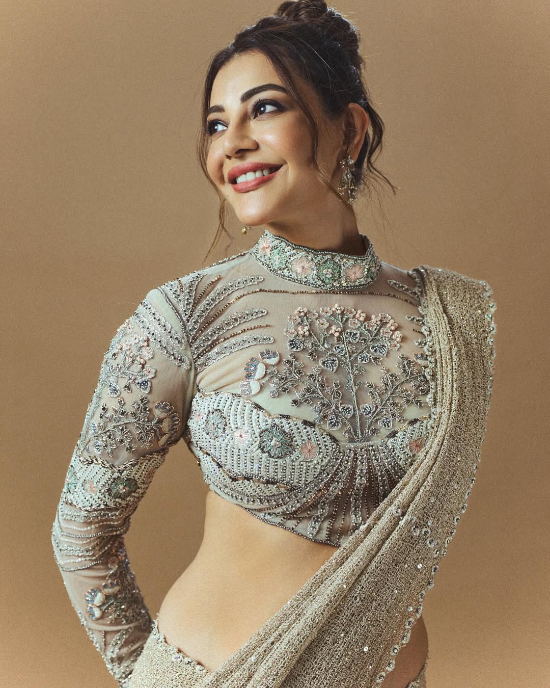 Kajal Aggarwal in an elaborate, heavily embellished traditional Indian outfit studio portrait.