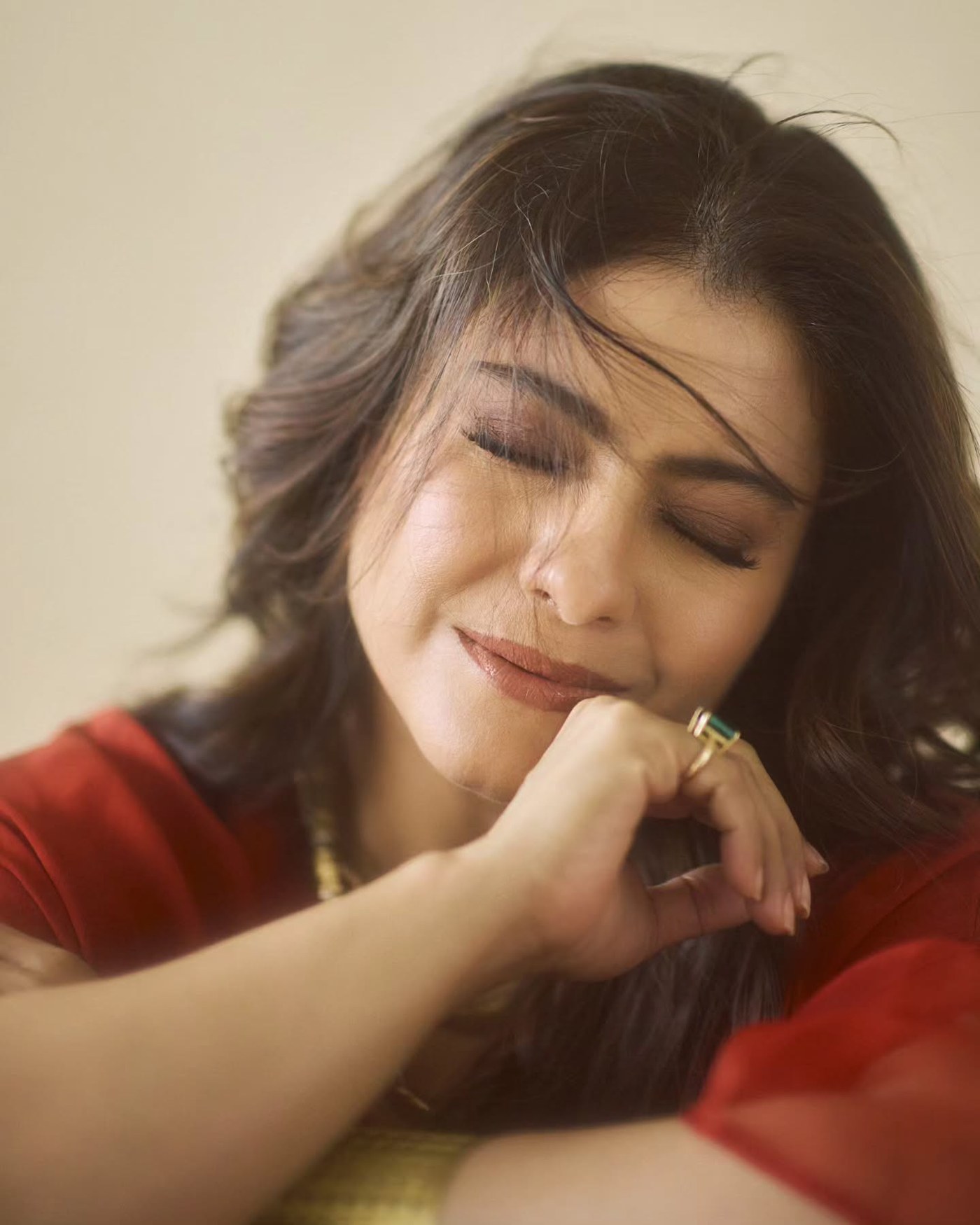 Kajol embodies radiant joy while dressed in an elegant flowing red outfit during a rainy day mood shoot.