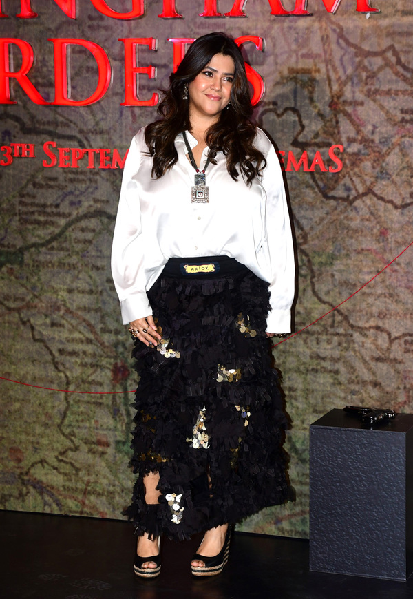 Kareena Kapoor poses elegantly against a rustic backdrop wearing an ornate gold outfit.
