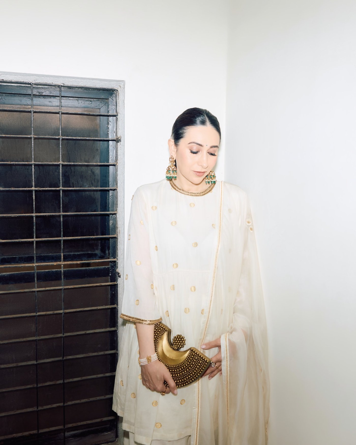 Karisma Kapoor showcases her regal elegance in a beautifully embroidered cream anarkali outfit.