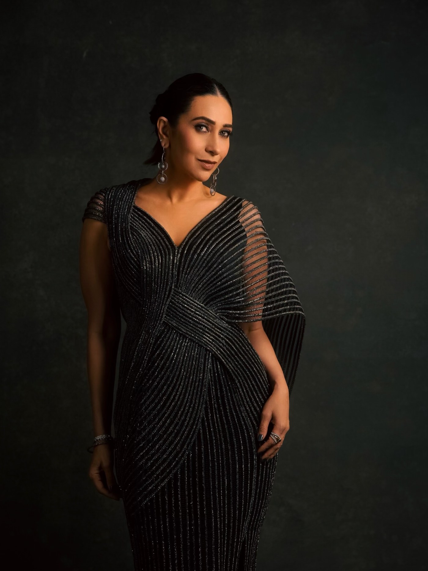 Karisma Kapoor showcases a black sari-inspired ensemble at an event. - Photos & Updates