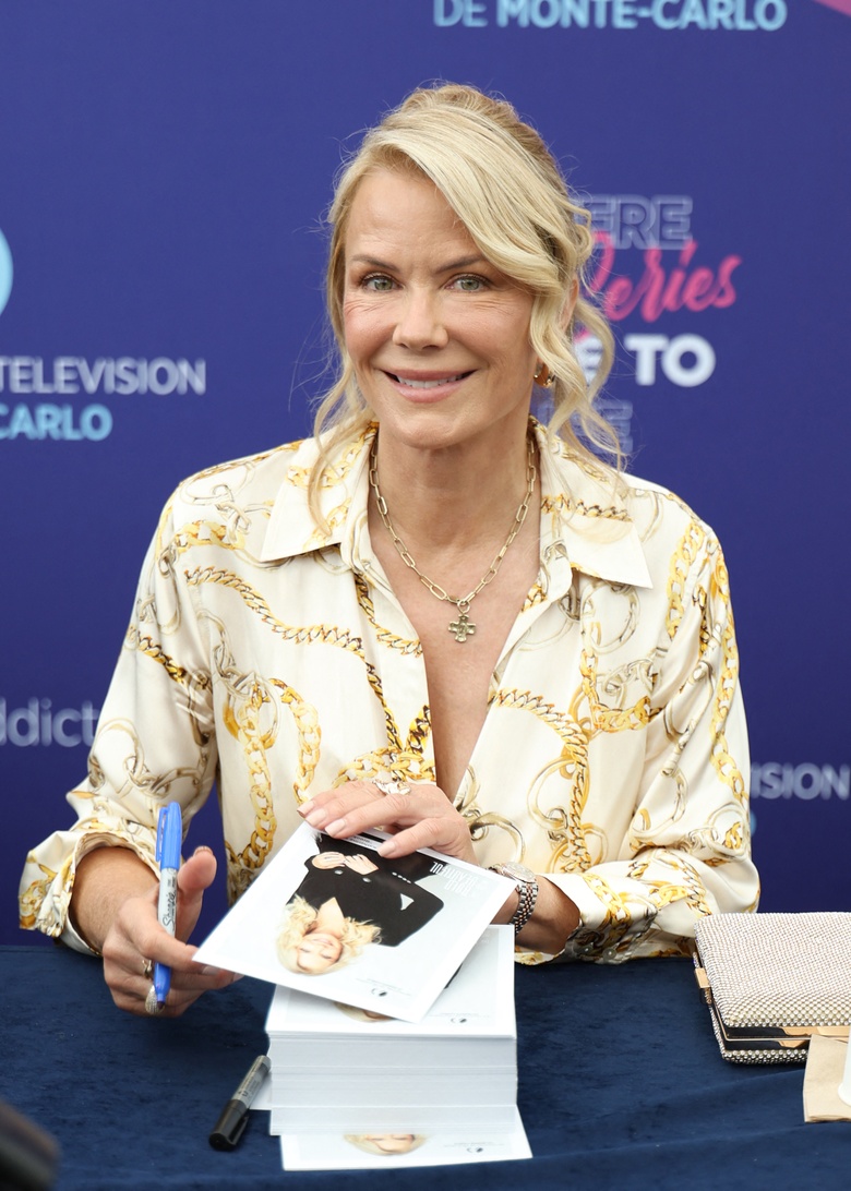 Katherine Kelly Lang posing elegantly in a stunning, richly detailed outfit at an event.