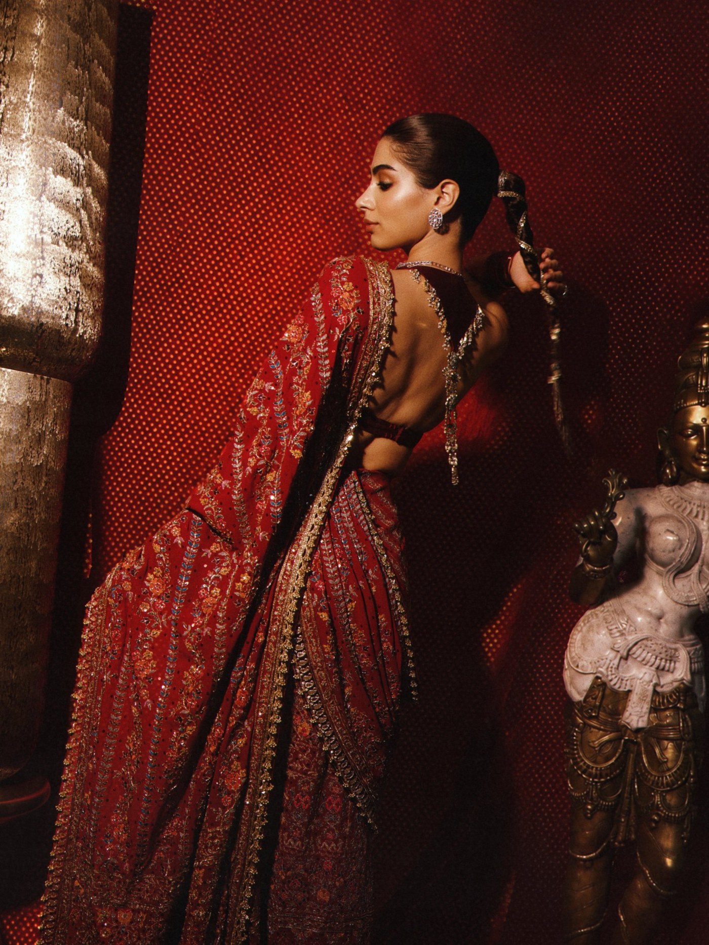 Khushi Kapoor in a vivid red ensemble featuring intricate embellishments and rich zari-inspired work.