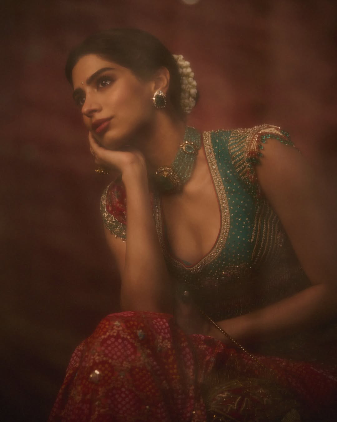 Khushi Kapoor showcases a magnificent traditional ensemble featuring rich red, green tones, and intricate embroidery work.