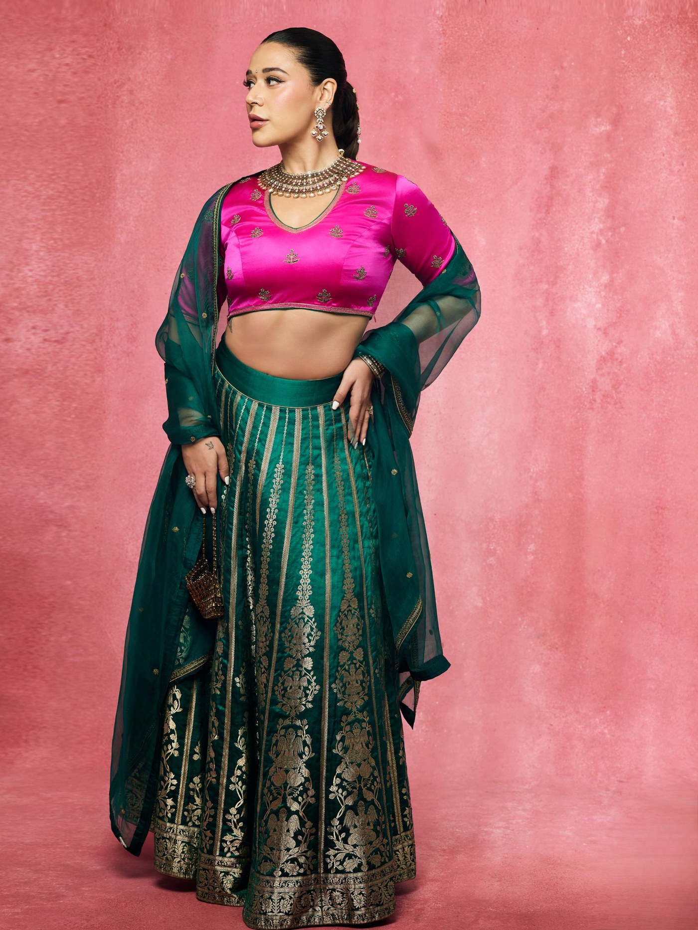 Krishna Shroff showcases a vibrant fuchsia blouse and emerald lehenga look.