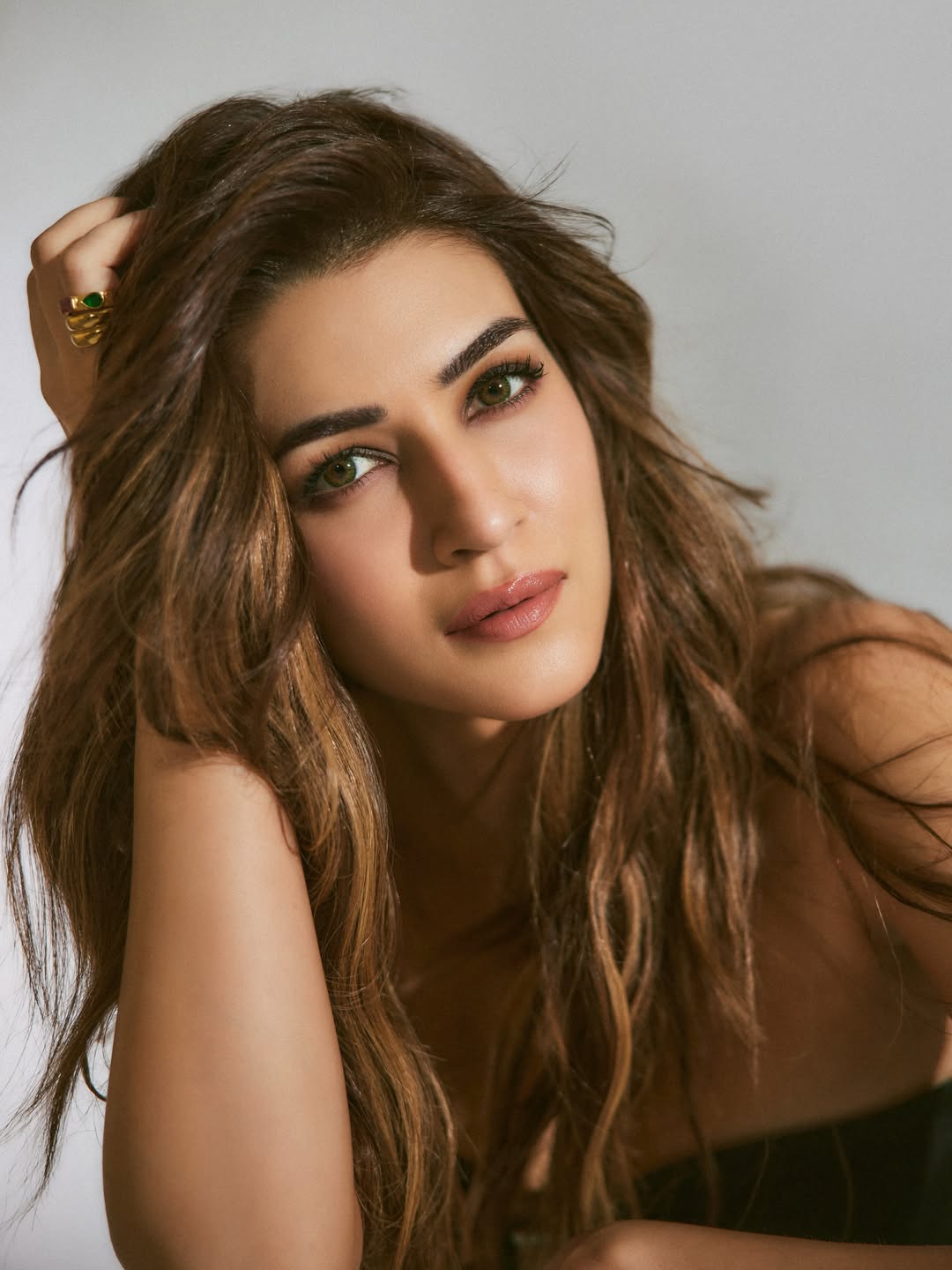 Kriti Sanon posing elegantly in a vibrant outfit at an event.