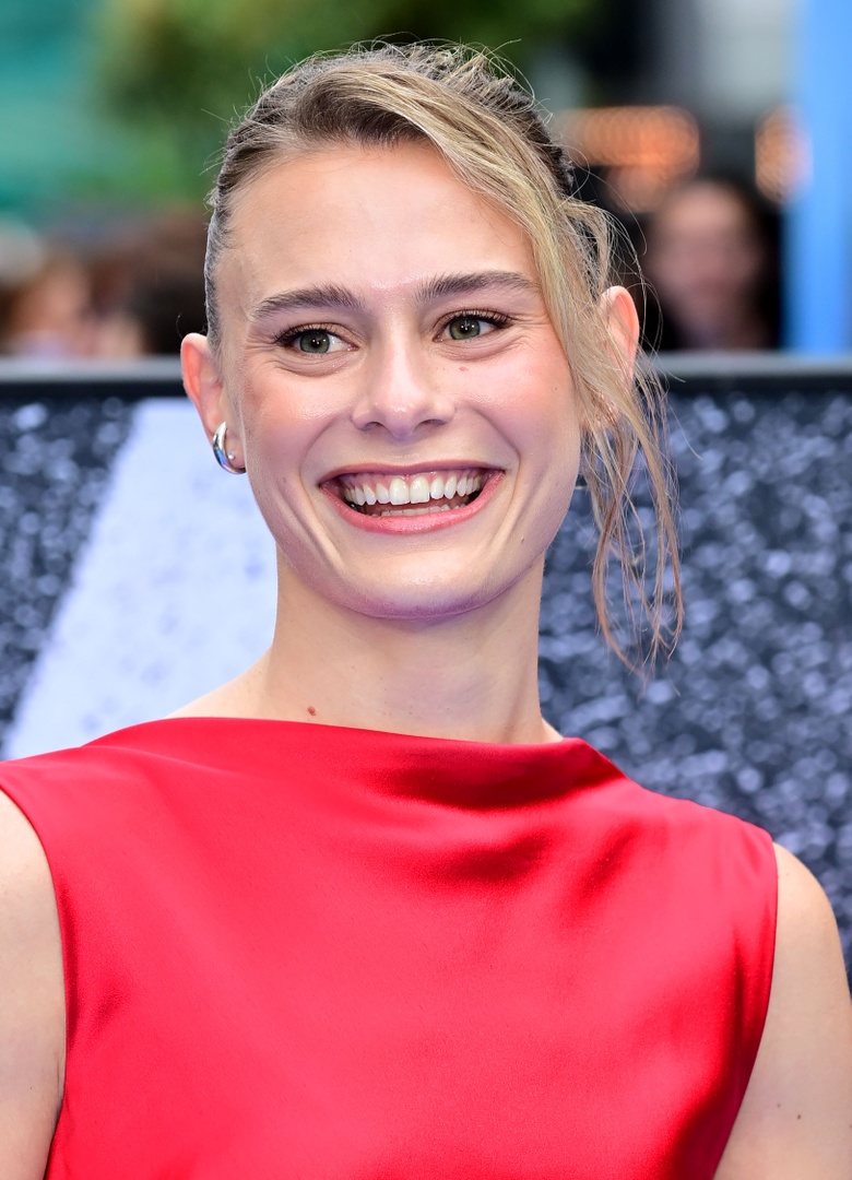 Louisa Binder posing elegantly in a striking red gown at the event.
