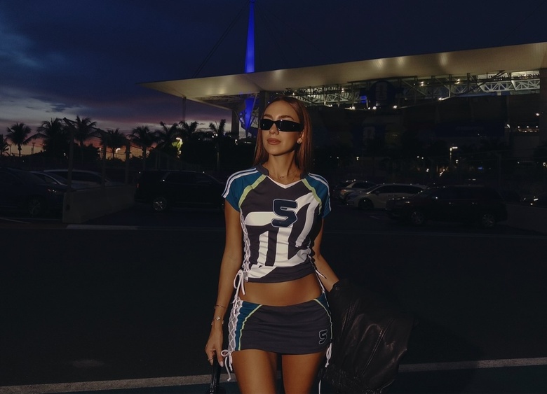 Luana Barron posing confidently at an event, showcasing a stylish outfit.
