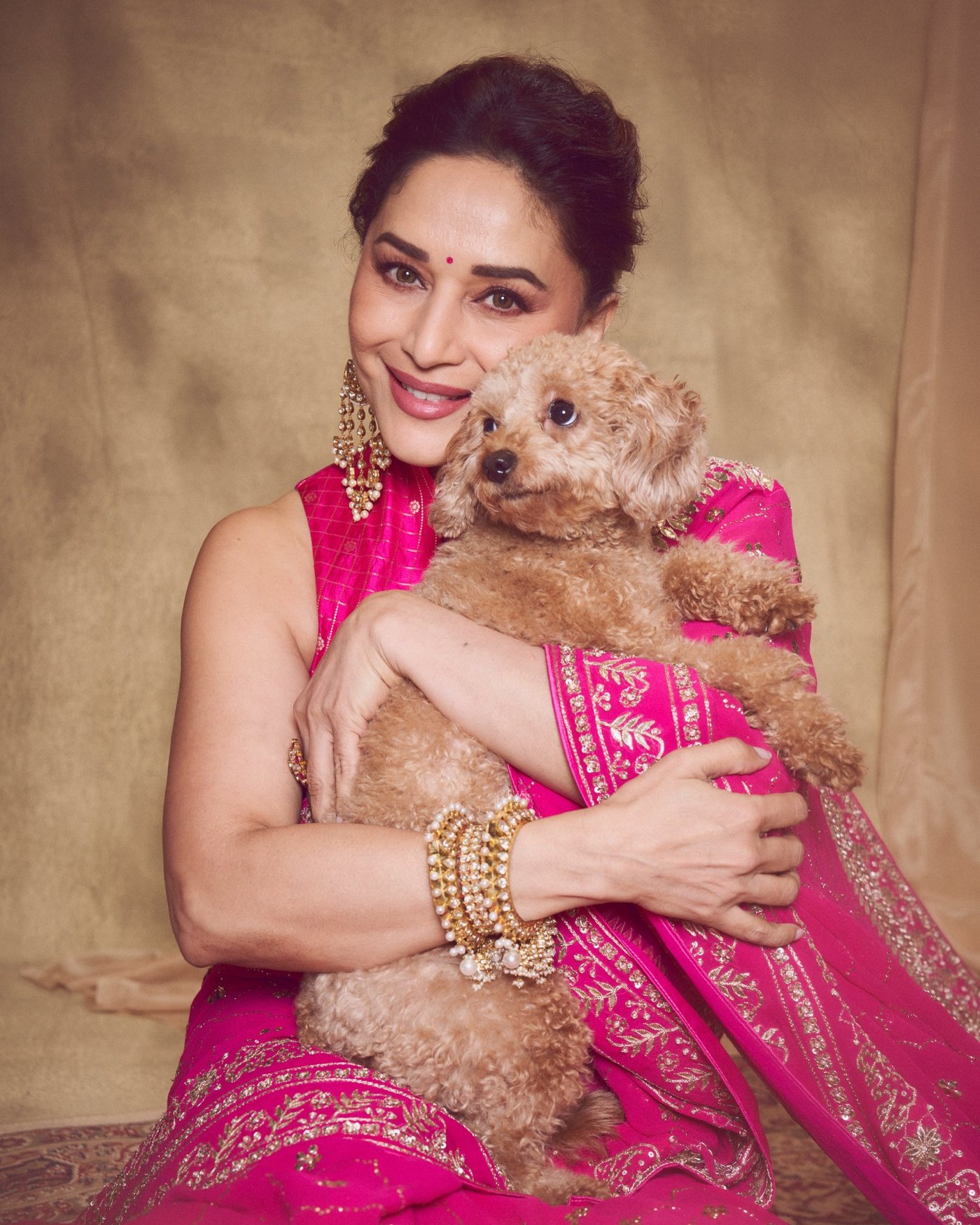 Madhuri Dixit is seen draped in a vibrant pink embroidered saree with husband Dr. Shriram Madhav Nene.