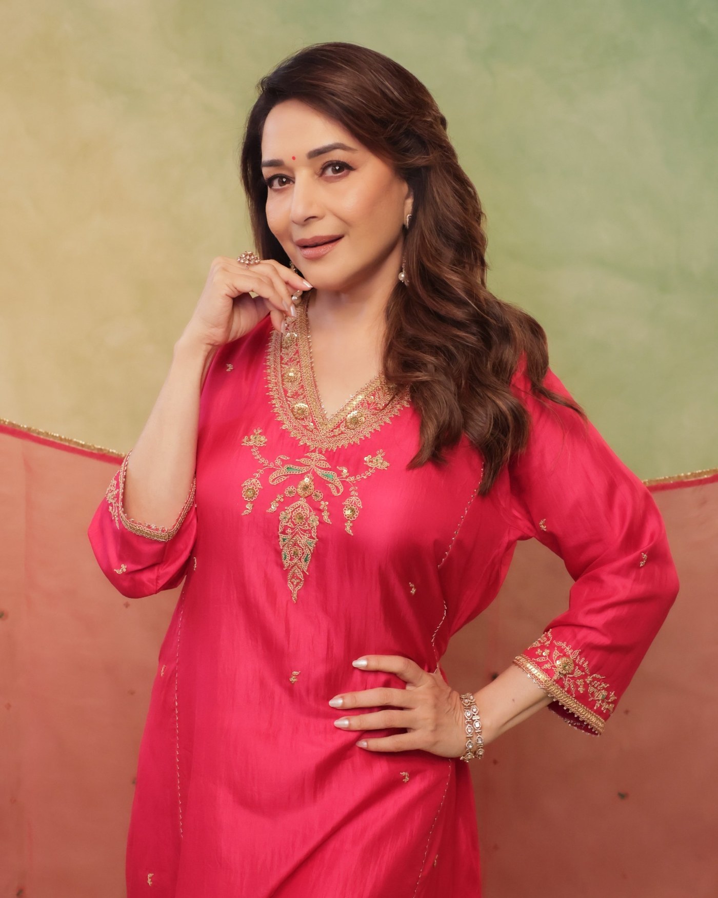 Madhuri Dixit radiates festive joy wearing a beautiful, richly embroidered pink outfit for a celebration. - Photos & Updates