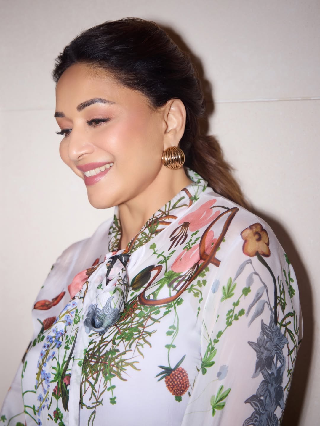 Madhuri Dixit smiling brightly while posing at an event.