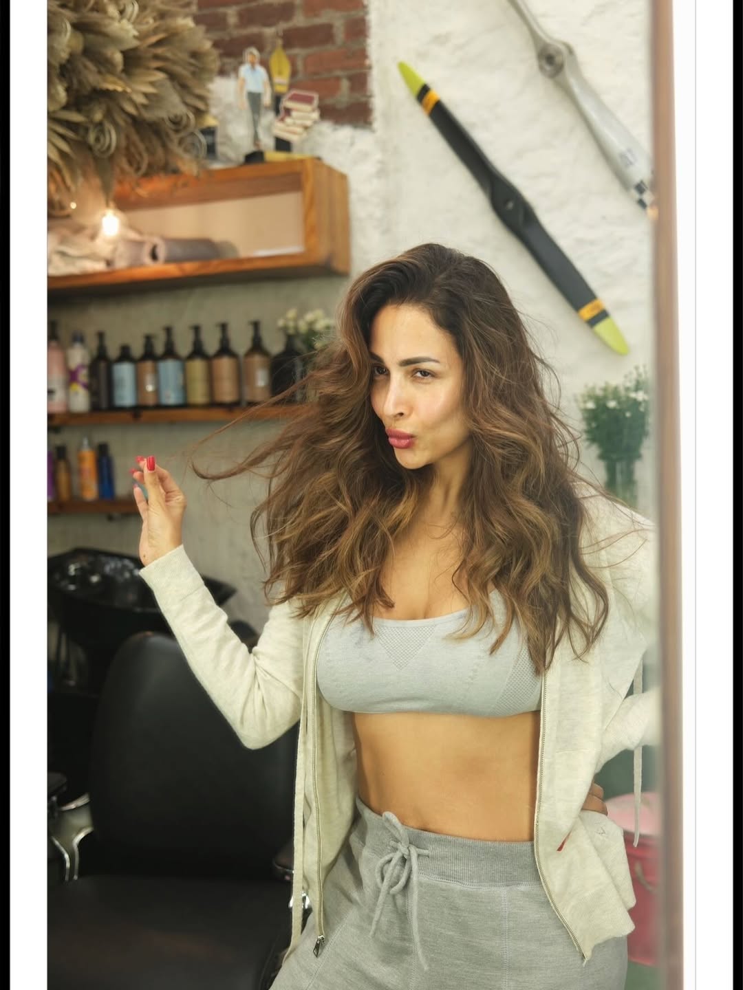 Malaika Arora showcases a chic athleisure look featuring a grey crop top and soft oversized hoodie.