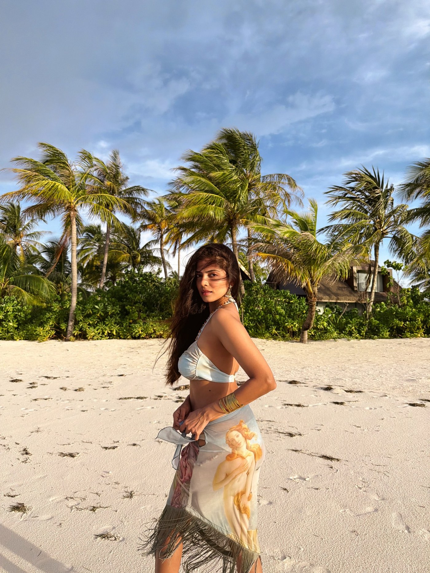 Malavika Mohanan showcases a stunning bohemian ensemble against a picturesque coastal backdrop.