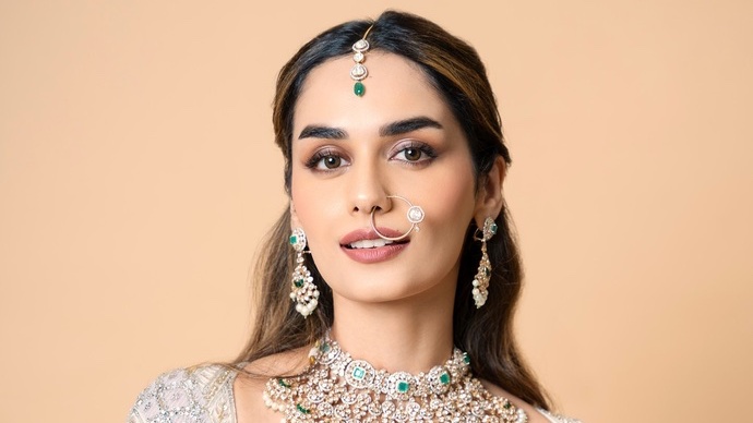 Manushi Chhillar poses gracefully wearing a stunning gold and green ensemble.