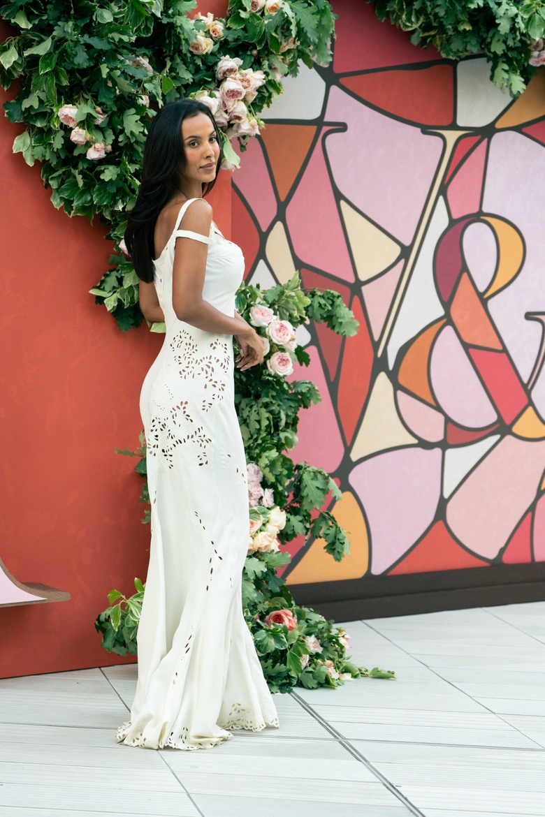 Maya Jama posing elegantly in a vibrant outfit at the event.