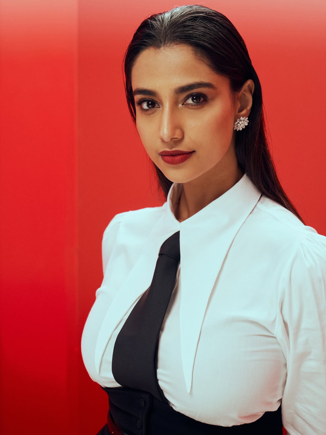 Meenakshi Chaudhary in a structured black peplum skirt and white blouse. - Photos & Updates
