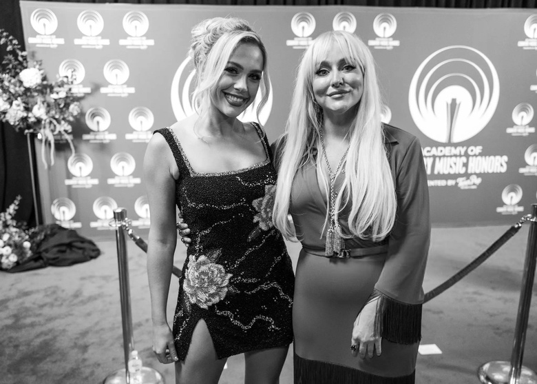 Megan Moroney is seen posing with a beautiful smile and elegant ensemble at a major music event. - Photos & Updates
