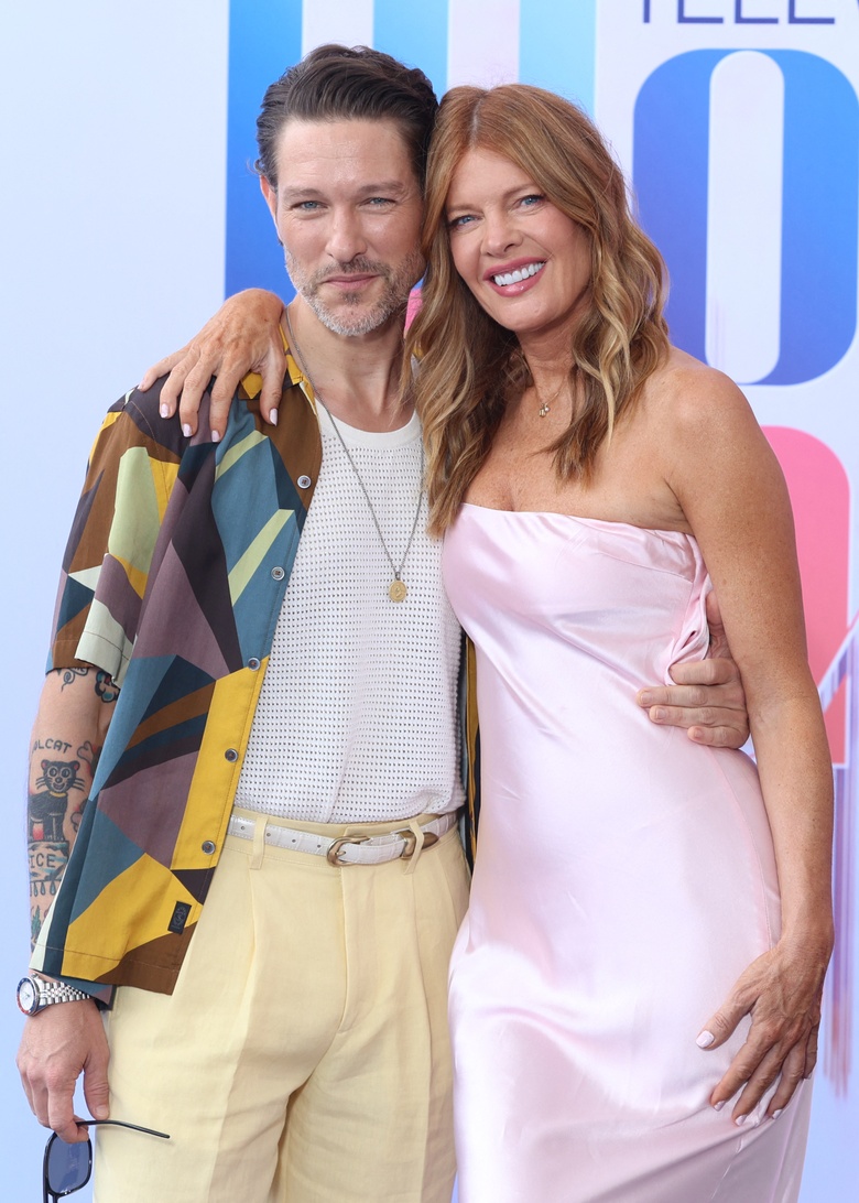 Michelle Stafford posing elegantly in a vibrant red outfit at an evening event.