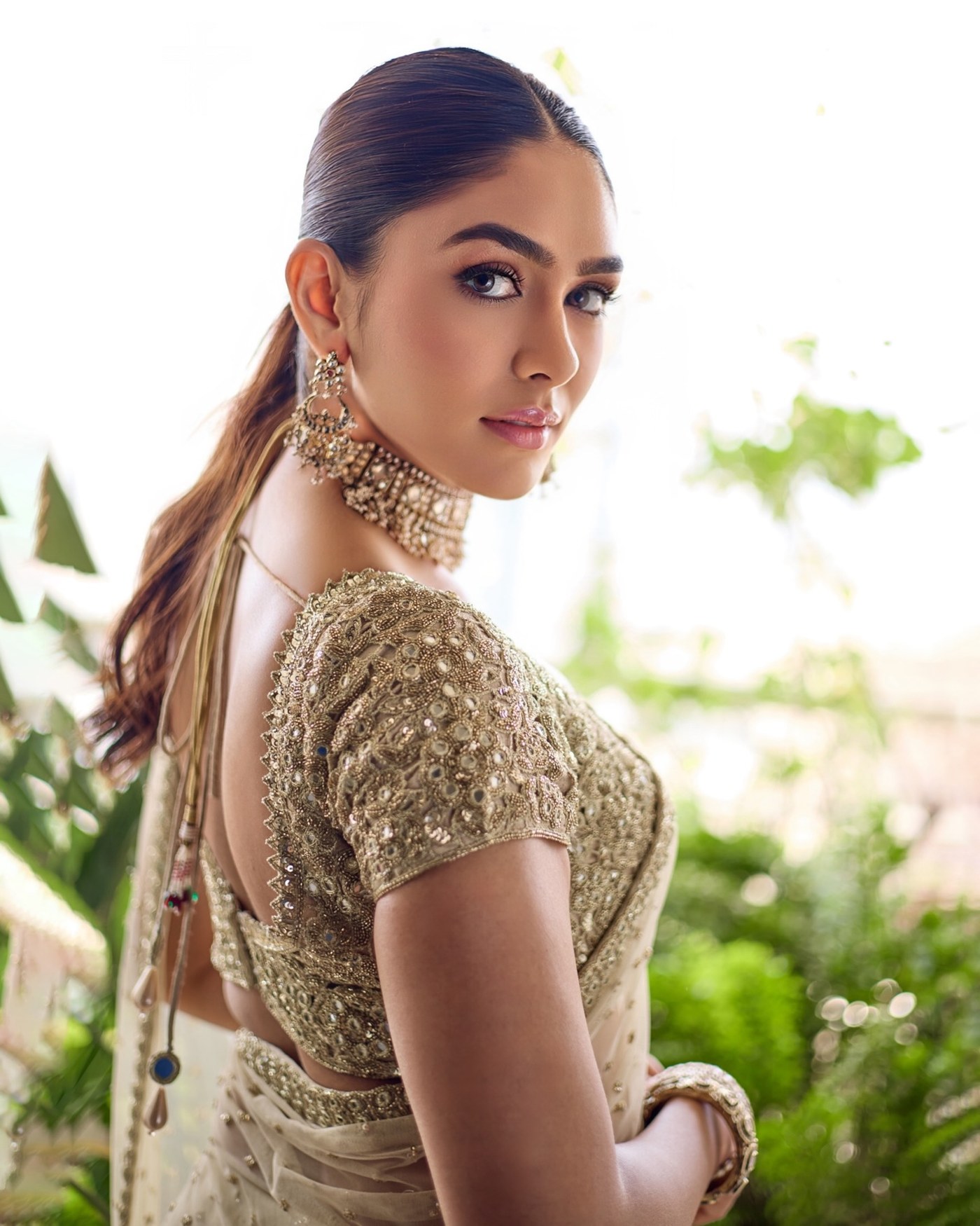 Mrunal Thakur draped in an intricately embroidered beige-gold saree, showcasing graceful ethnic elegance.