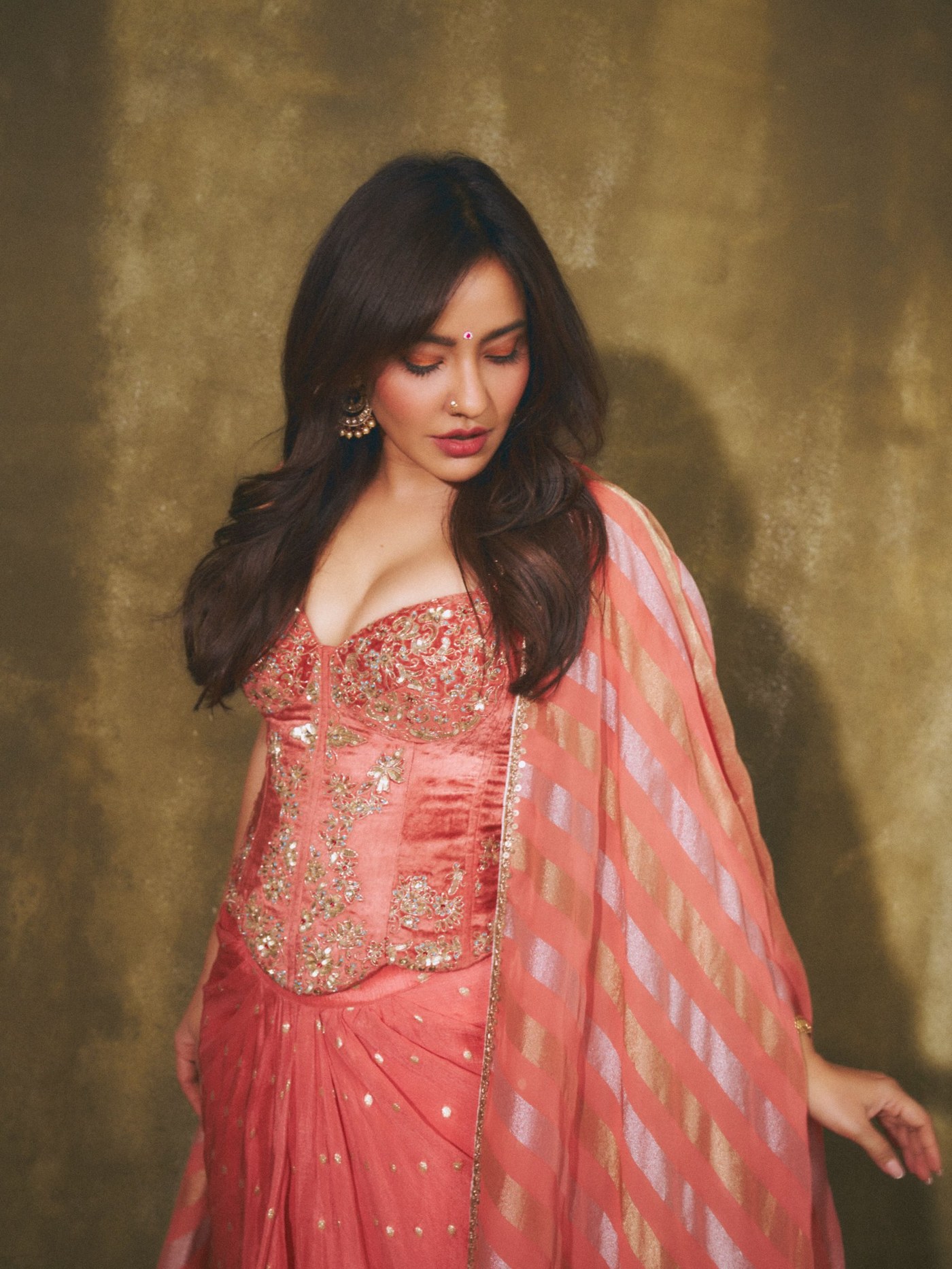 Neha Sharma wears a vibrant coral lehenga-style ensemble featuring intricate embroidery and a striped dupatta. - Photos & Updates