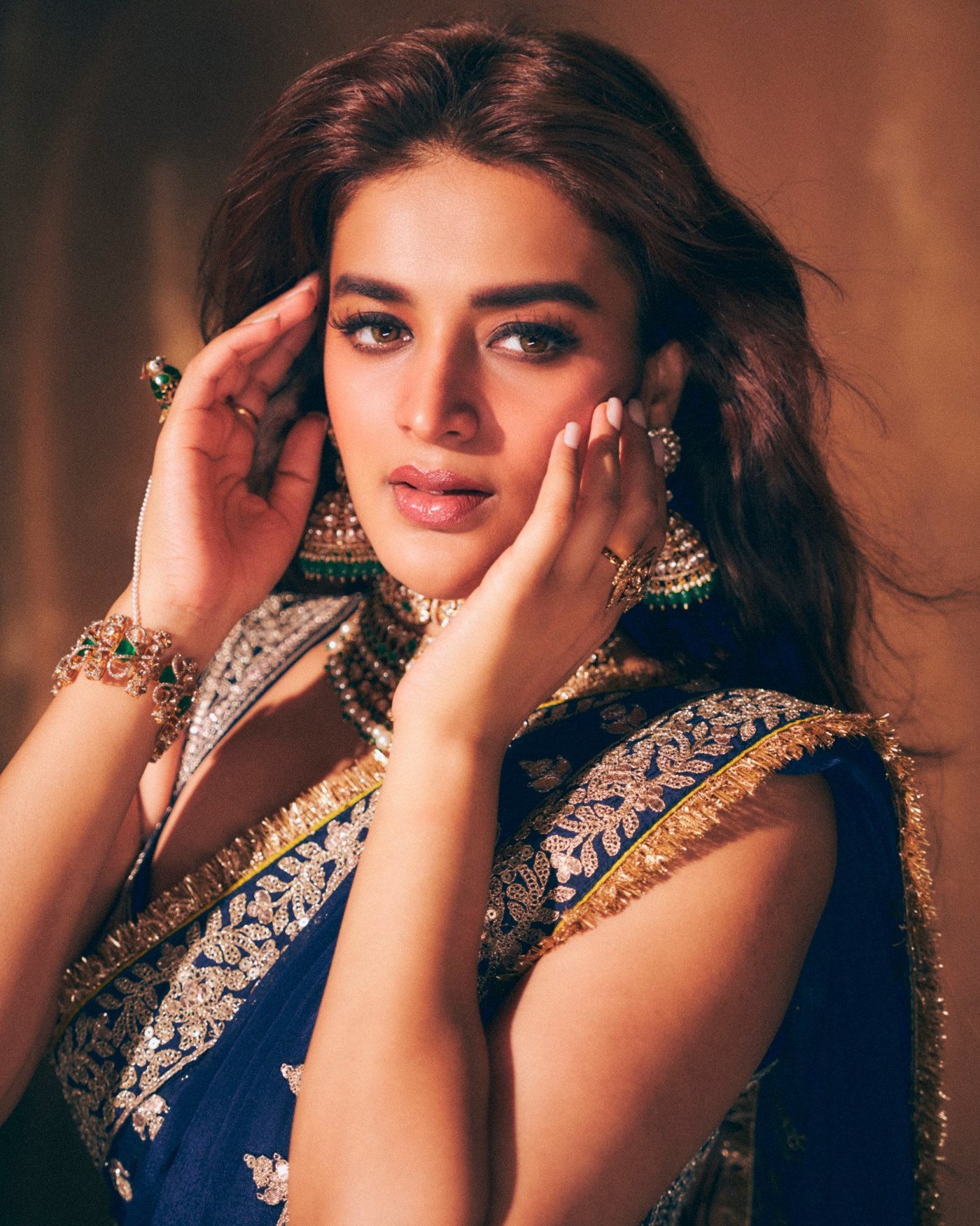 Nidhhi Agerwal is seen showcasing regal elegance draped in a stunning royal blue saree with traditional jewelry.