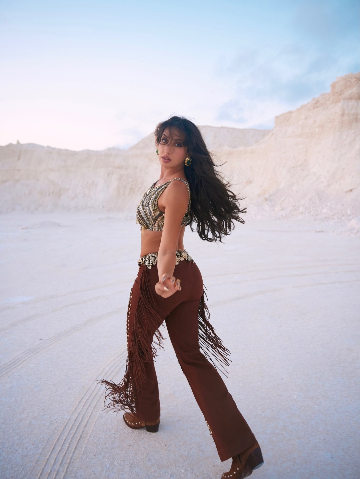 Nora Fatehi showcases an eclectic, bohemian look featuring a richly embellished crop top and earthy trousers.