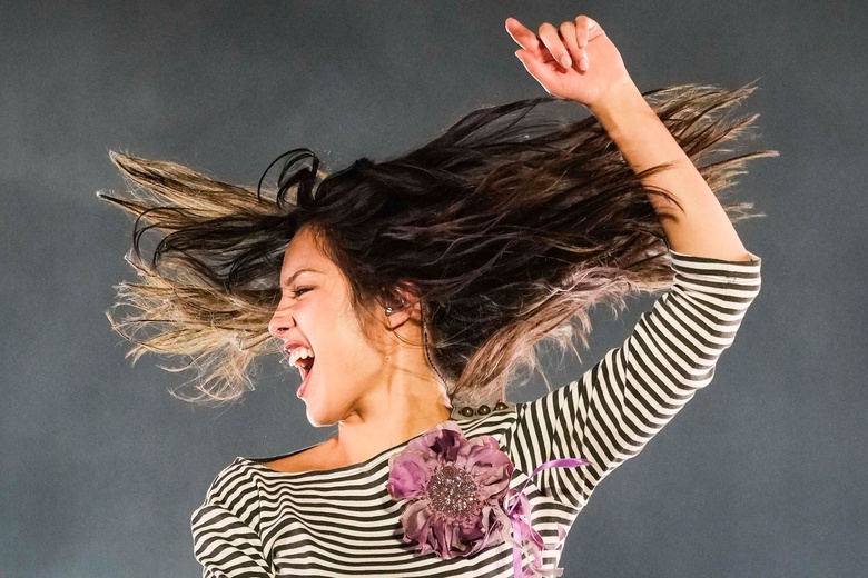 Olivia Rodrigo posing in a bright, casual setting with expressive facial gestures.