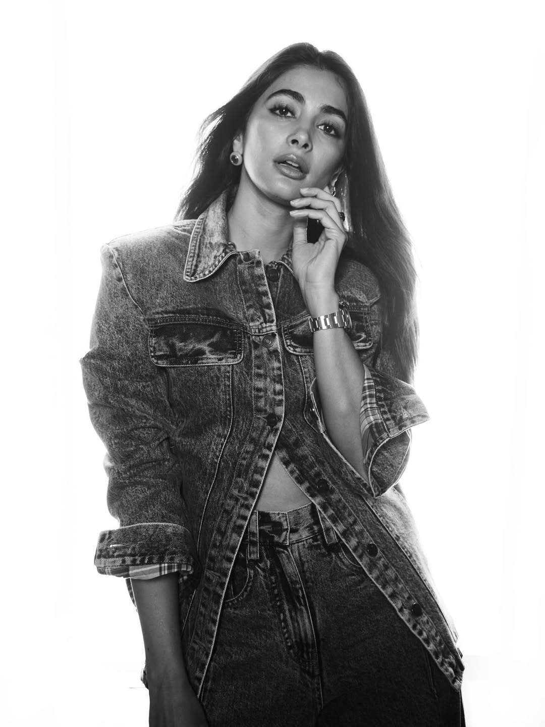 Pooja Hegde in a close-up portrait wearing a medium blue denim jacket and resting her hand near her chest.